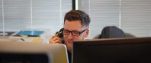 Man in office setting using telephone.
