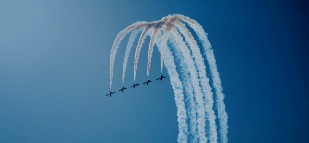 Five plane aerobatics team perform synchronised inside loop